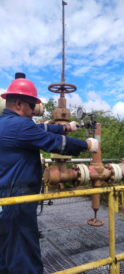 Operador maniobrando válvulas en líneas de flujo